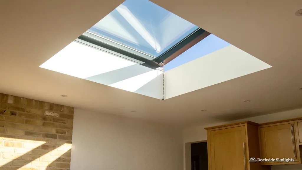 Rooflight open in a kitchen ceiling with blue sky through the gap