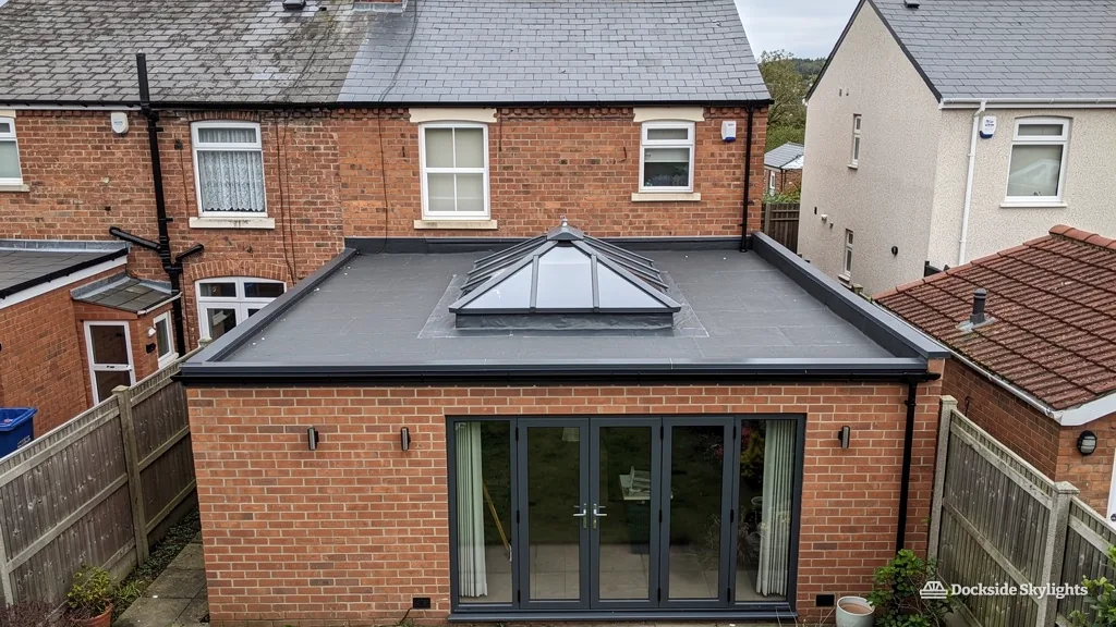 Single-storey rear extension on a brick semi with a roof lantern on the dark grey flat roof above bifold doors